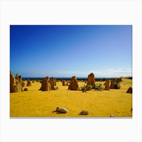 Orange Sand With Dark Rock Formations And Deep Blue Sky Canvas Print