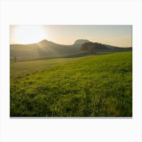 Sunset over a green field Canvas Print
