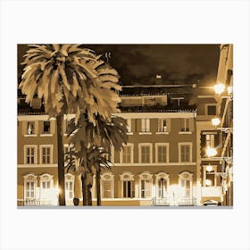 Nighttime scene with two palm trees in the foreground, their fronds silhouetted against a backdrop of a city street. The buildings are rendered in a sepia tone, with warm yellow lights emanating from windows and street lamps. The scene is bathed in a soft, warm glow, creating a sense of tranquility and charm. Canvas Print