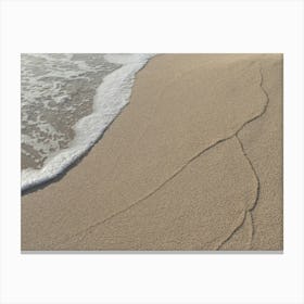 Sea water and traces of waves on the beach Canvas Print