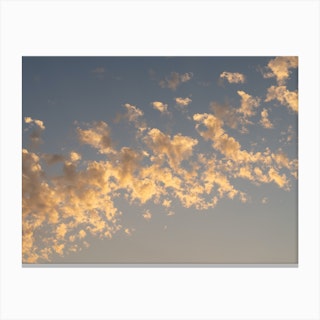 Golden clouds in the pale blue sky at sunset Canvas Print