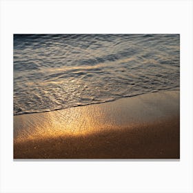 Sea water meets golden sand at sunrise Canvas Print