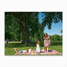 Family Of Four Enjoying A Day At The Park Scattered Picnic Items Children In Mid Laughter Chasing (3) Canvas Print