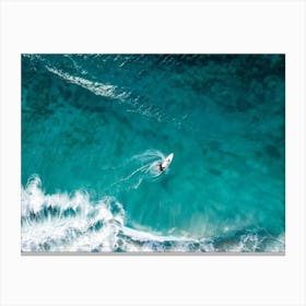 Aerial View Capturing A Single Surfer Carving Through The Azure Waves Silhouetted Against The Cryst Canvas Print