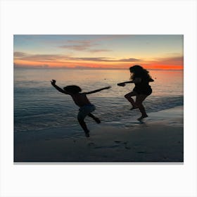 Jumping into the beach sunset Canvas Print