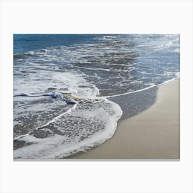 Blue sea water meets sand on the beach Canvas Print