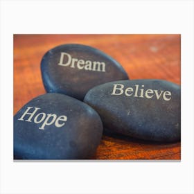 Black Inspirational Pebble Stones With The Words Dream, Believe And Hope On Wooden Background Canvas Print