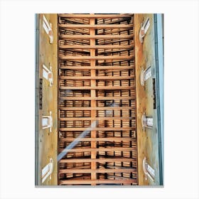 Architectural Ceiling Design. This image showcases an intricately designed ceiling, featuring a series of wooden beams arranged in a grid pattern. The beams create a sense of depth and structure, with light filtering through the gaps, casting shadows that enhance the three-dimensional effect. The sides of the ceiling are adorned with decorative elements resembling windows, adding to the architectural beauty and complexity of the design. Canvas Print