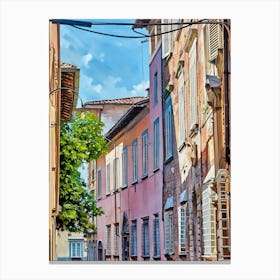 Lucca Sunlit Alley: A Stroll Through History. This image portrays a vibrant alleyway illuminated by soft sunlight, with tall, narrow buildings on either side. The perspective draws attention to the intricate facades, windows, and details that define this charming urban street, bustling with people and energy under a serene sky. Canvas Print