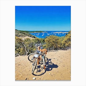 Bike Stop in Porquerolles with a Stunning Coastal View. Two bicycles rest on a sandy path overlooking a breathtaking Mediterranean bay dotted with anchored sailboats. The scene, framed by lush greenery and blue skies, captures the essence of a peaceful adventure along the coastline of Provence, France. Canvas Print