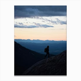 Silhouette Of A Lone Hiker Against A Vast Panorama Including Mountain Peaks Cutting Into The Horizo Canvas Print